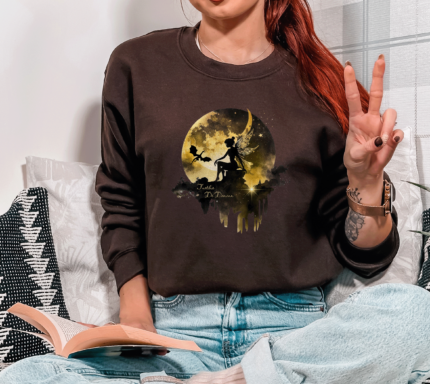 Tuath de danann Dark Academia Chocolate Sweatshirt, With Black Moon Fairy Image worn by girl sitting on a sofa.