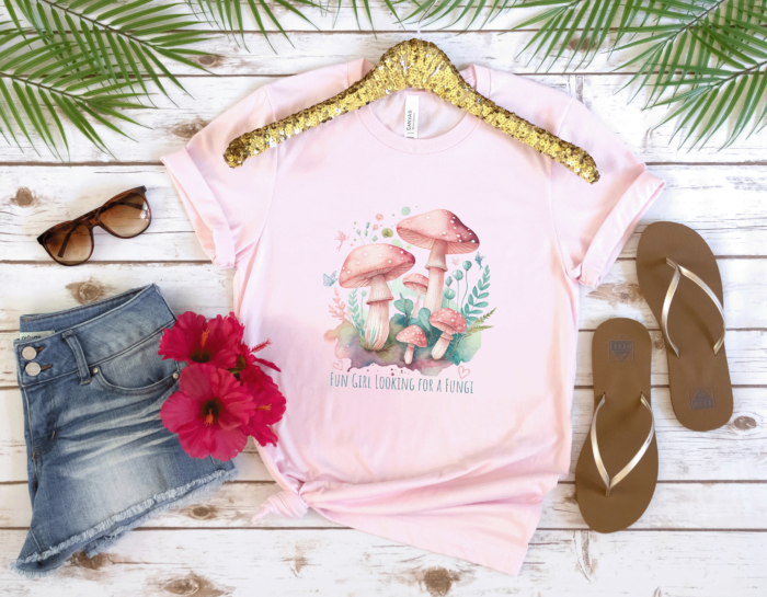 Funny Magical Mushroom T-shirt in soft pink, cute teal and pink fungi graphic, with the text: Fun Girl Looking for a Fungi - ideal gift for foragers.